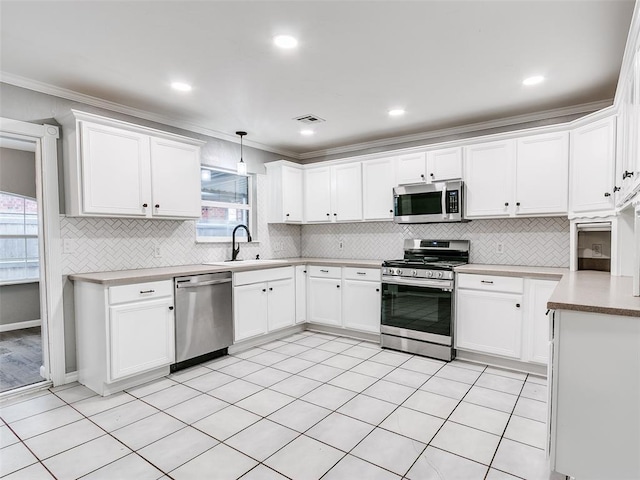 kitchen featuring white cabinets, decorative light fixtures, stainless steel appliances, and sink