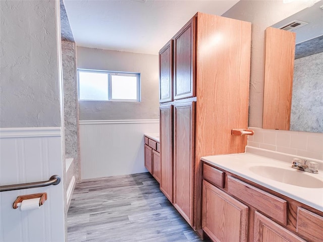 bathroom with vanity, wood-type flooring, and shower / washtub combination