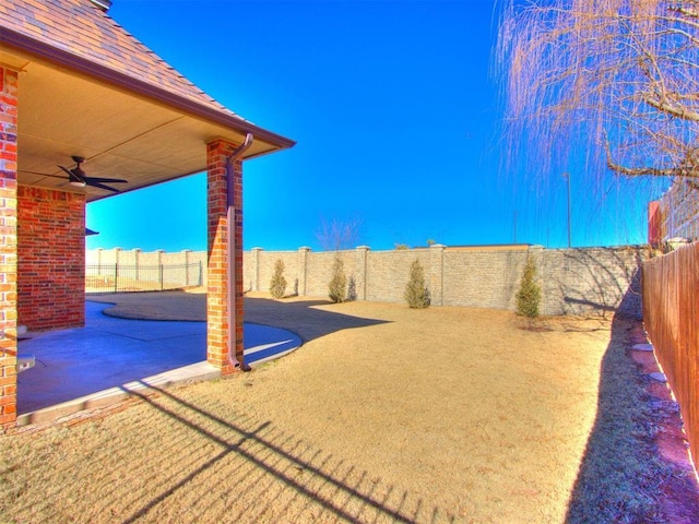 view of yard featuring ceiling fan and a patio area