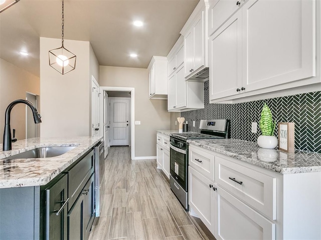 kitchen with white cabinetry, sink, hanging light fixtures, decorative backsplash, and appliances with stainless steel finishes