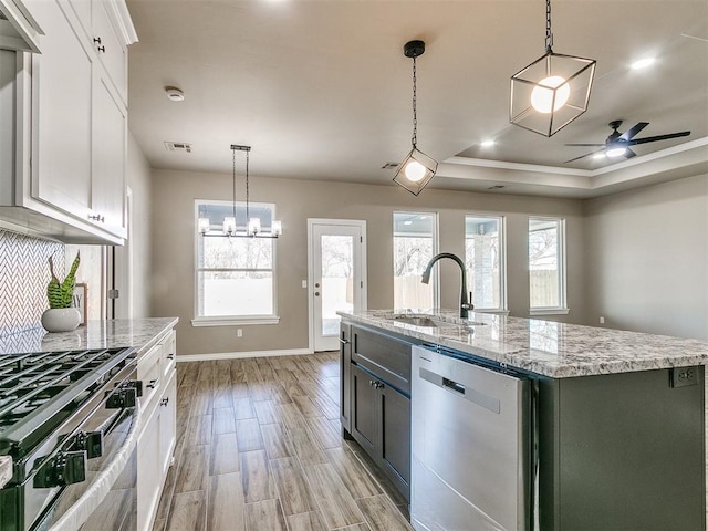 kitchen with white cabinets, sink, a center island with sink, and stainless steel appliances