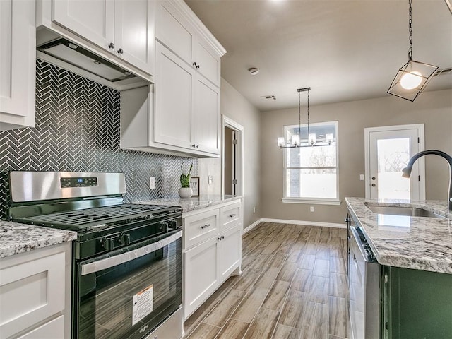 kitchen with pendant lighting, stainless steel appliances, white cabinetry, and sink