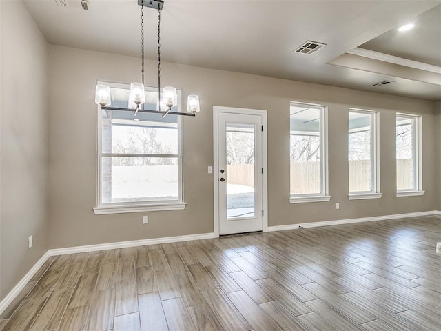 entryway featuring a tray ceiling and an inviting chandelier