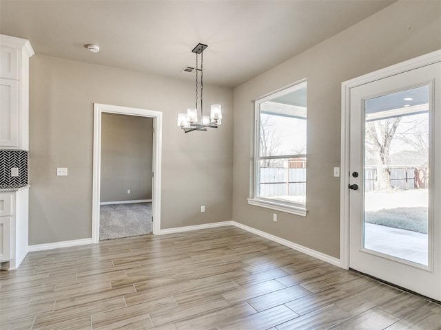 unfurnished dining area with a chandelier