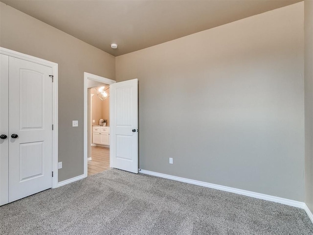 unfurnished bedroom with light carpet and a closet