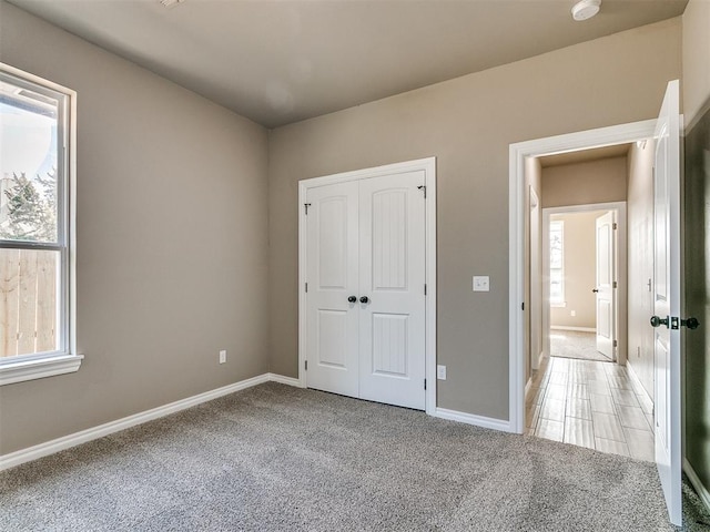 unfurnished bedroom featuring light carpet and a closet