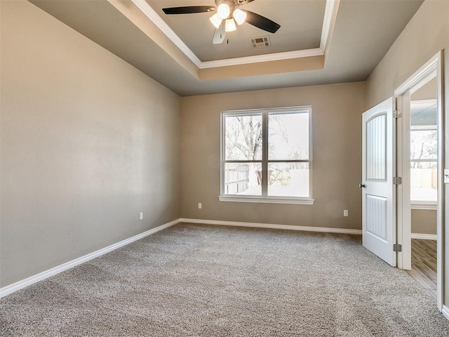 unfurnished room featuring carpet, ceiling fan, and a raised ceiling