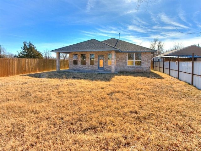 back of house with a lawn and a patio