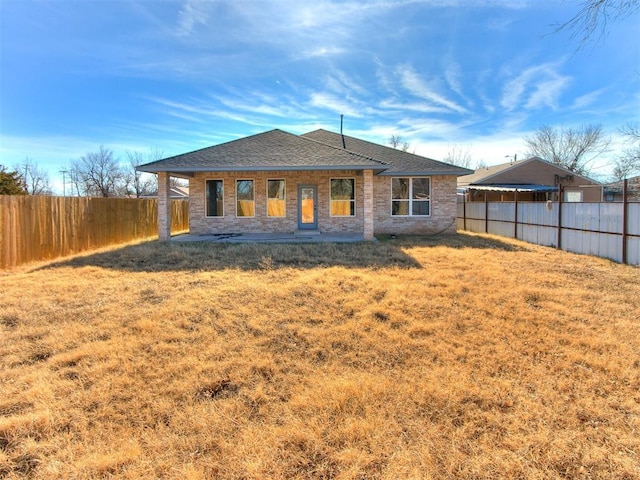 rear view of property featuring a lawn and a patio