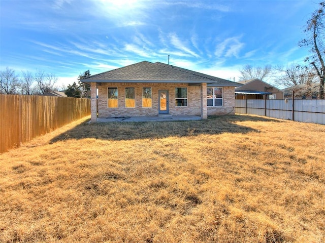 rear view of property featuring a yard and a patio