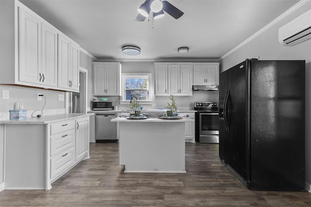 kitchen featuring a wall mounted AC, white cabinetry, a kitchen island, and appliances with stainless steel finishes