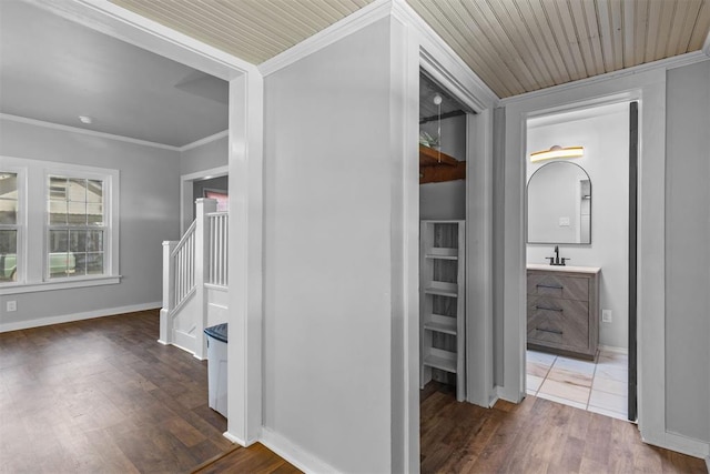 hall with dark hardwood / wood-style flooring, wood ceiling, ornamental molding, and sink