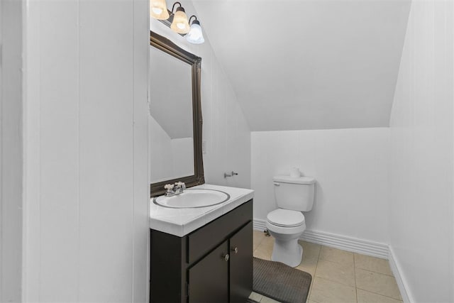 bathroom with tile patterned flooring, vanity, toilet, and vaulted ceiling