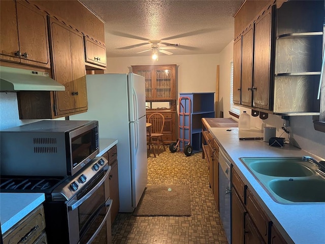 kitchen with sink, stainless steel appliances, a textured ceiling, and ceiling fan