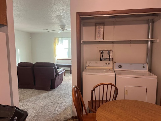 clothes washing area featuring ceiling fan, washing machine and dryer, a textured ceiling, and carpet flooring