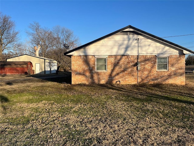 view of home's exterior with brick siding and a yard