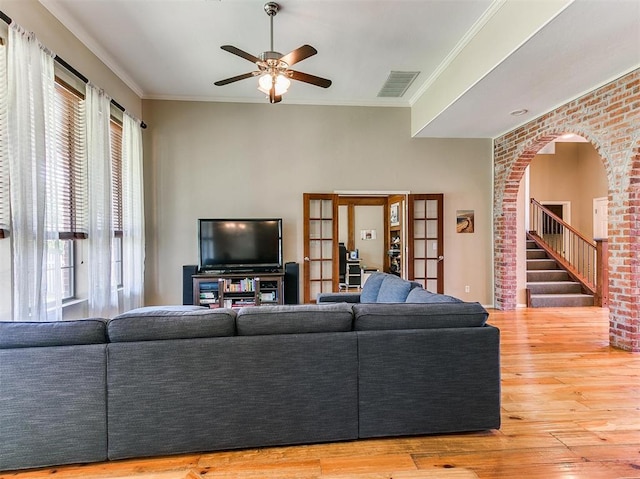 living room featuring french doors, hardwood / wood-style flooring, ceiling fan, and crown molding