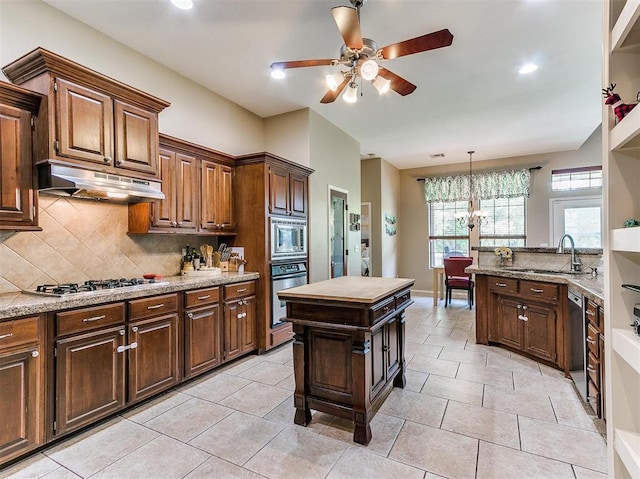 kitchen featuring light stone countertops, sink, decorative backsplash, light tile patterned flooring, and appliances with stainless steel finishes