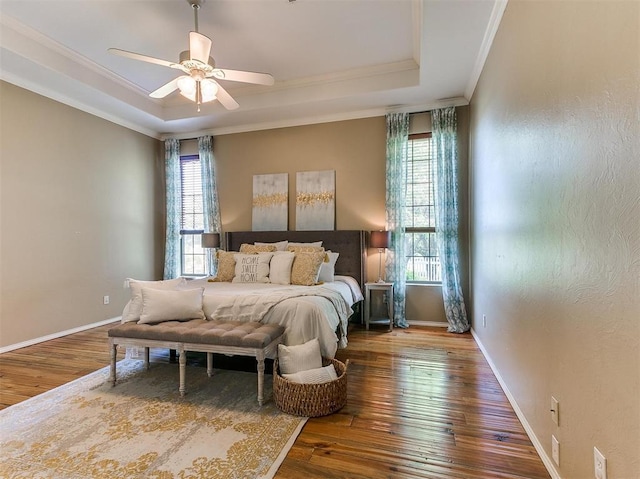 bedroom featuring a tray ceiling, ceiling fan, hardwood / wood-style floors, and crown molding