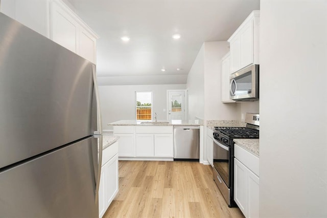 kitchen with light stone countertops, white cabinets, and appliances with stainless steel finishes