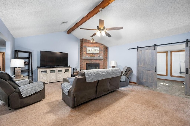 living room featuring a barn door, lofted ceiling with beams, a textured ceiling, light carpet, and a fireplace