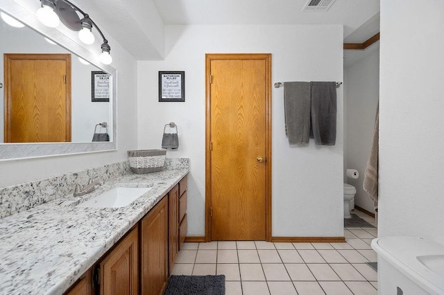 bathroom with toilet, vanity, tile patterned floors, and crown molding