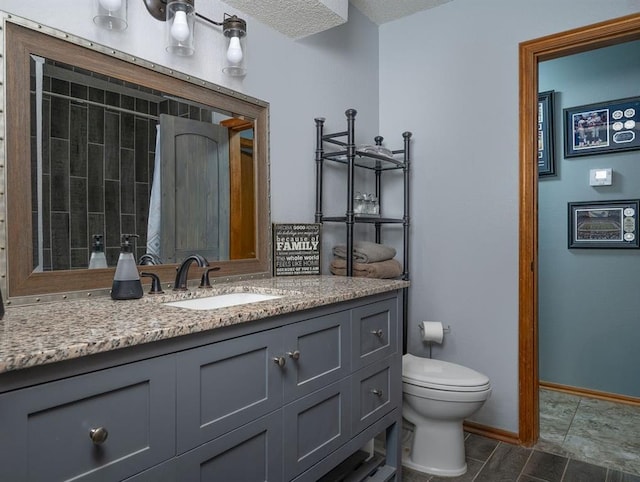 bathroom featuring vanity, toilet, and a textured ceiling