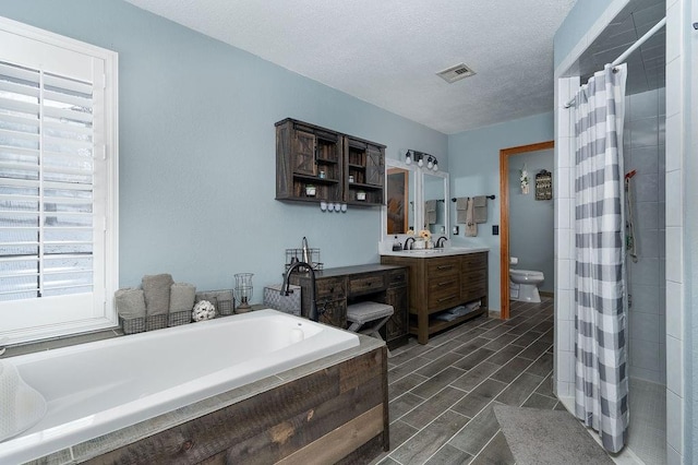 full bathroom with vanity, shower with separate bathtub, toilet, and a textured ceiling