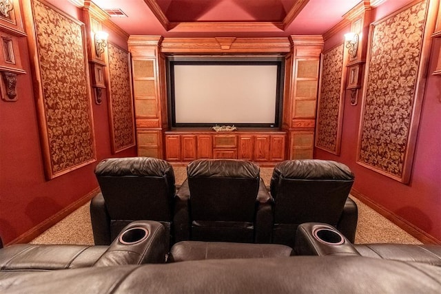 carpeted cinema with a raised ceiling and ornamental molding