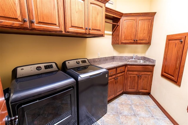 laundry area featuring washer and dryer, cabinets, light tile patterned floors, and sink