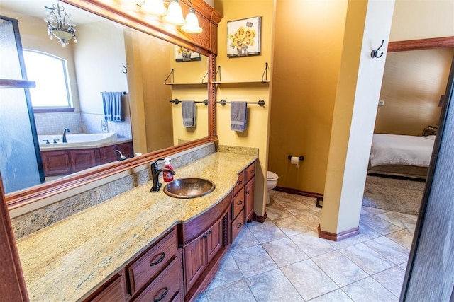 bathroom with tile patterned floors, a washtub, vanity, and toilet