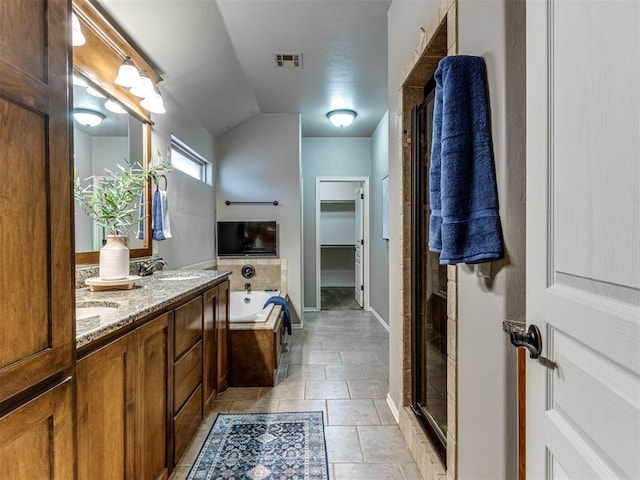 bathroom featuring tile patterned floors, separate shower and tub, vanity, and lofted ceiling