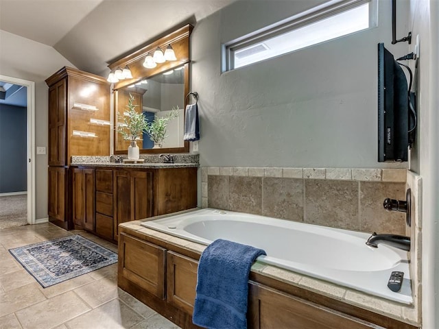 bathroom featuring vanity, a tub to relax in, tile patterned floors, and lofted ceiling