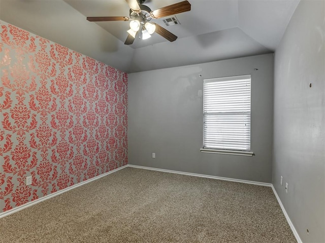 carpeted spare room featuring ceiling fan and vaulted ceiling