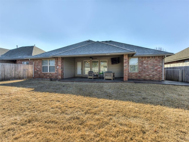 rear view of property with a yard, ceiling fan, and a patio area