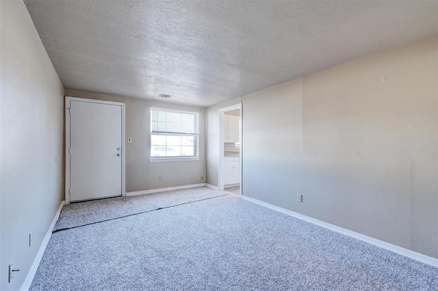 spare room with carpet and a textured ceiling