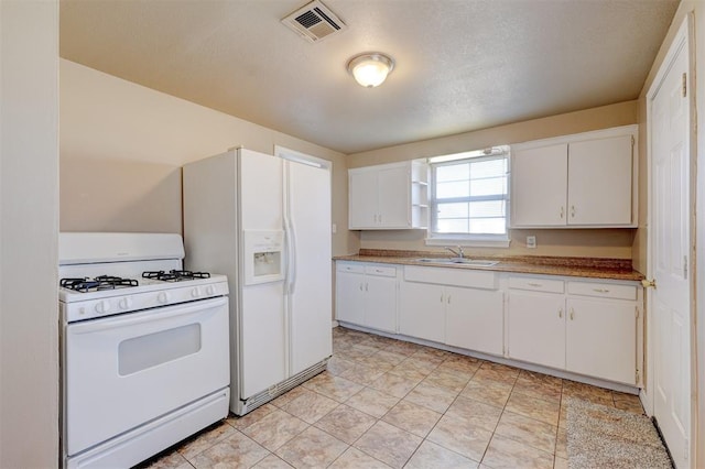 kitchen with white cabinetry, sink, and white appliances