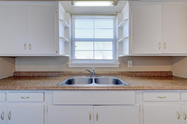 kitchen featuring white cabinetry and sink