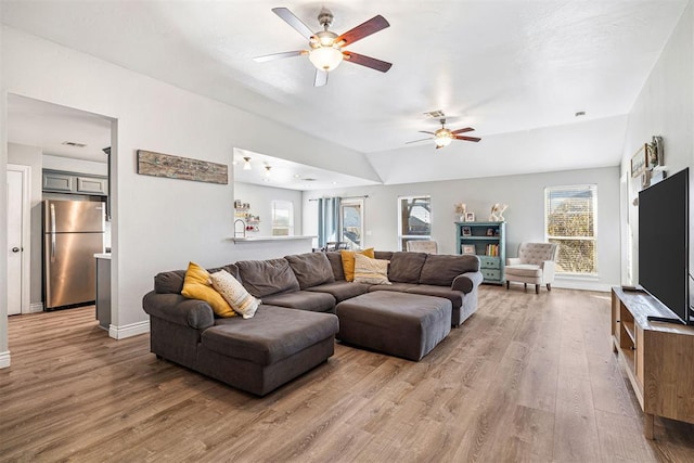 living room featuring hardwood / wood-style floors, ceiling fan, and lofted ceiling