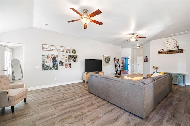 living room with hardwood / wood-style floors, ceiling fan, and vaulted ceiling