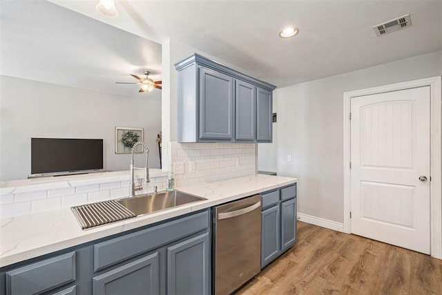 kitchen featuring backsplash, sink, stainless steel dishwasher, ceiling fan, and hardwood / wood-style flooring