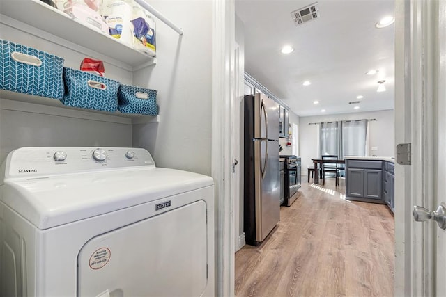 laundry area with washer / clothes dryer and light hardwood / wood-style flooring