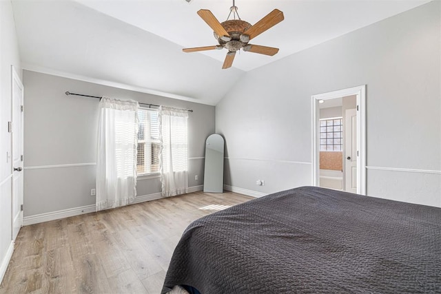 unfurnished bedroom featuring ceiling fan, light hardwood / wood-style flooring, ensuite bathroom, and vaulted ceiling