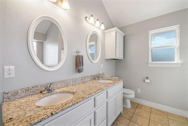 bathroom featuring tile patterned flooring, vanity, lofted ceiling, and toilet