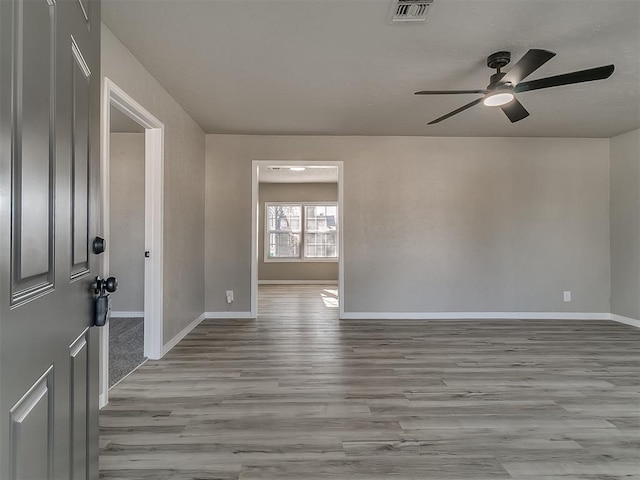 empty room featuring light hardwood / wood-style flooring and ceiling fan