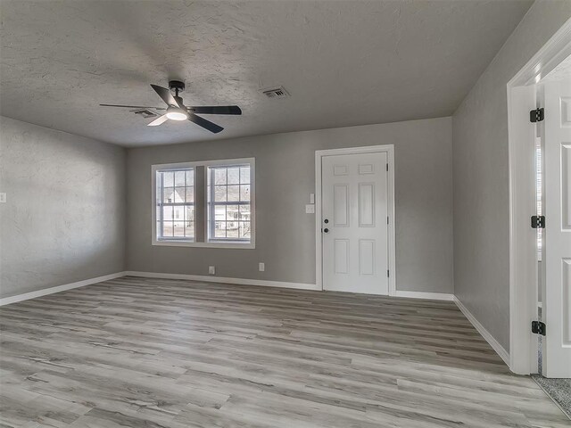 interior space featuring ceiling fan, a textured ceiling, and light hardwood / wood-style flooring