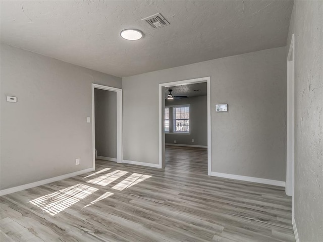 unfurnished room with light wood-type flooring and ceiling fan