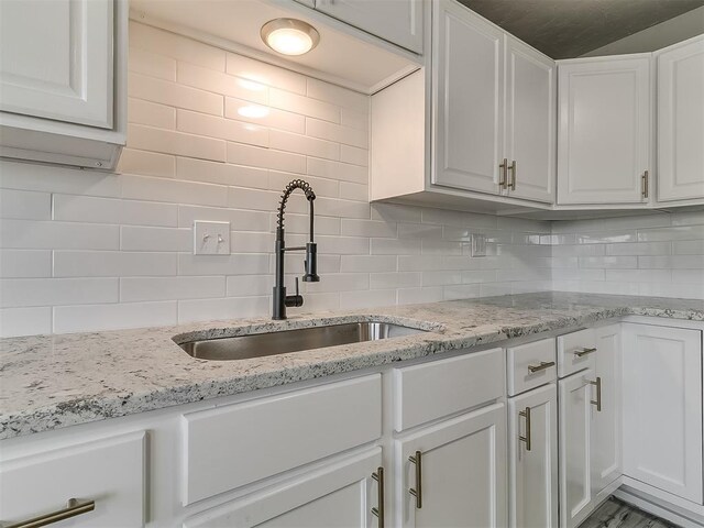 kitchen featuring white cabinets, tasteful backsplash, and sink