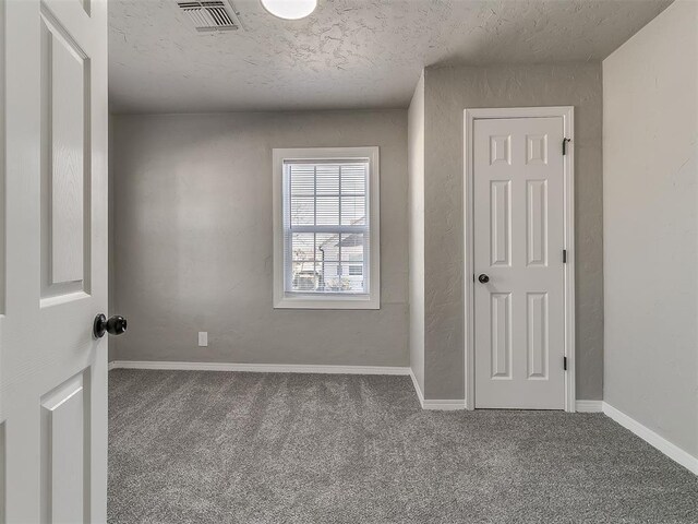 carpeted spare room featuring a textured ceiling