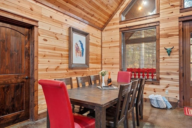 dining area with wood ceiling, wooden walls, and vaulted ceiling